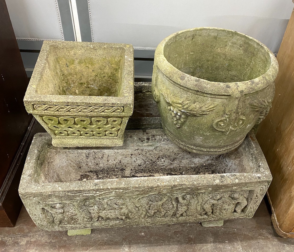 A pair of rectangular reconstituted stone garden planters length 80cm, a circular planter and smaller square planter.